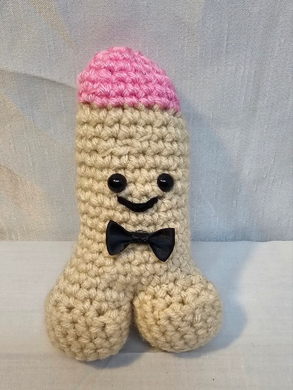 Handmade Crocheted Plush Toy with Pink Tip and Black Bow